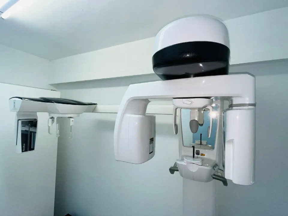 El equipo de radiología visto de cerca, con la cúpula del escáner 3D, el brazo de la telerradiografía a la izquierda y el soporte donde se apoya la cabeza